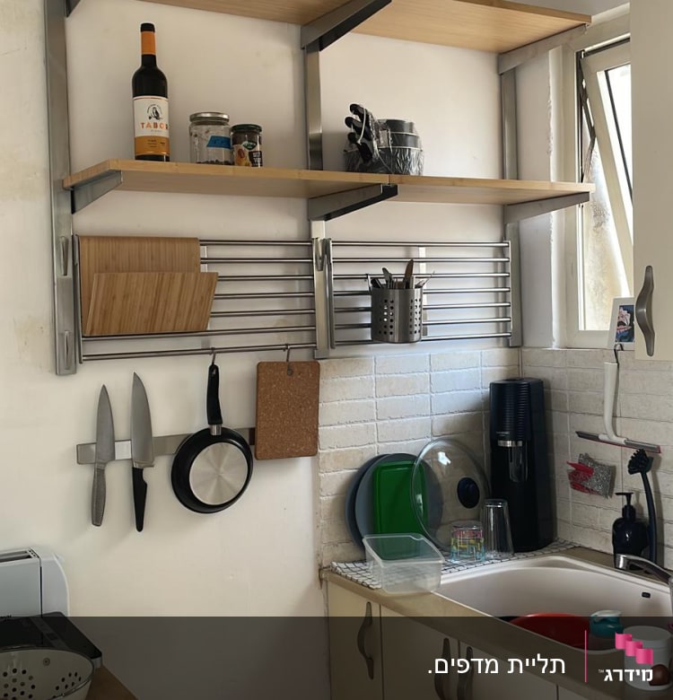 מדפים עם כלים, סכינים תלויים, קרש חיתוך